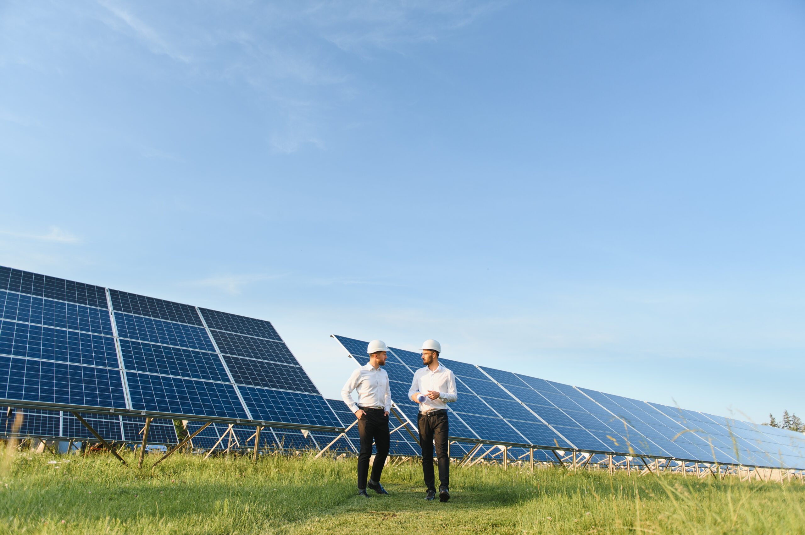 The solar farm(solar panel) with two engineers walk to check the operation of the system, Alternative energy to conserve the world's energy, Photovoltaic module idea for clean energy production The solar farm(solar panel) with two engineers walk to check the operation of the system, Alternative energy to conserve the world's energy, Photovoltaic module idea for clean energy production